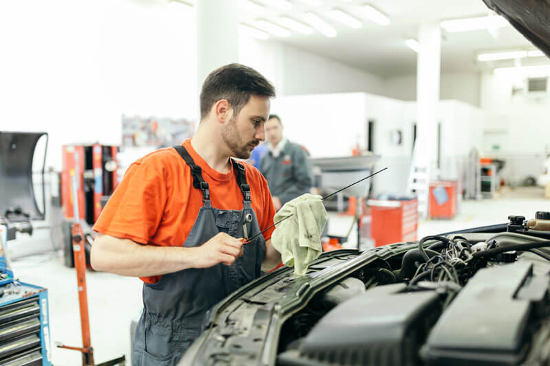 a mechanic inspecting a car inside a workshop